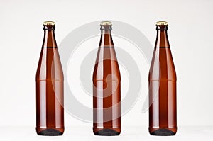 Set of three brown NRW beer bottles 500ml mock up. Template for advertising, design, branding identity on white wood table.