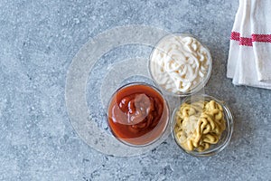Set of Three Classic Sauce Ketchup, Mayonnaise and Mustard in Small Glass Bowls.