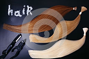Set of of three colors hair extension tools on a dark background. copyspace. top view. photo