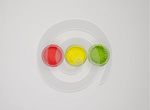 set of three colors of neon colored acrylic powders simulating a traffic light