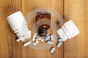 A set of three different bottles of pills and a variety of colour pills.