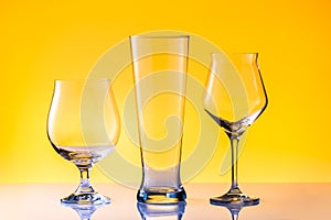 Set with three different empty beer glasses on white golden background. Alcohol concept