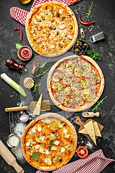 Set of three different pizzas on a dark background, Fast food lunch, top view