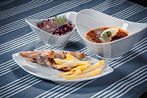 Set of three dishes. Business lunch of three dishes. Three dishes on white plates on a table with a blue tablecloth photo