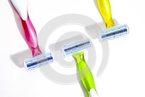 Set of three multi-colored female razors for shaving isolated on white background.