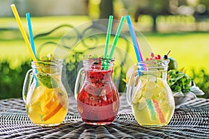 Set of three summer lemonade with ice and fruit like lemon, orange, lime and mint leaf, summer drink with soda isolated on white b