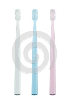 Set of three toothbrushes of different colors isolated on white background.