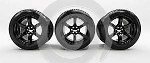 A set of threer black car tires and wheels with a five-spoke design, presented in a row against a clean white background