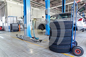 A set of tires for seasonal replacement near the lift in the tire workshop