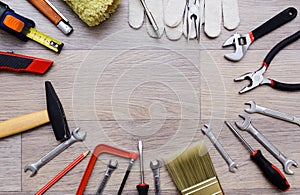 A set with tool on a wooden table. Hammer, screwdriver, gayachnye wrenches, pliers, wire cutters. Top view.