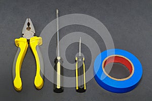 A set of tools on a gray background pliers, screwdriver