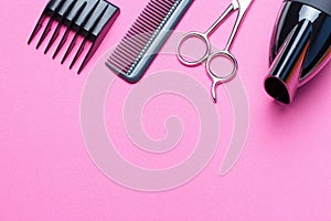 A set of tools for the hairdresser, hairdryer, scissors, comb, on a pink background, copy of the space