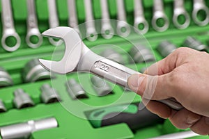 A set of tools for repair in car service - mechanic`s hands, close up. Auto mechanic with working tools for repair and diagnostic