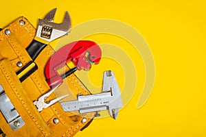 Set of tools in suede bag on yellow background prepared by the plumber master before repair or construction