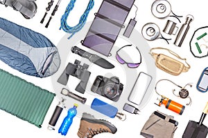 Set of tourist trekking items on white background. Top view of accessories for travel. Equipment for travel and hiking. Survival