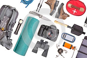 Set of tourist trekking items on white background. Top view of accessories for travel. Equipment for travel and hiking. Survival