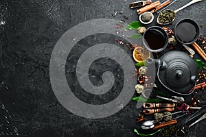 Set traditional Chinese tea on black stone background. Tea in teapot and cup. Top view.