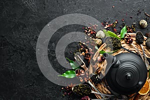 Set traditional Chinese tea on black stone background. Tea in teapot and cup. Top view.