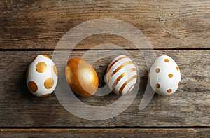 Set of traditional Easter eggs decorated with golden paint on wooden background