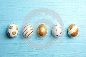 Set of traditional Easter eggs decorated with golden paint on wooden background