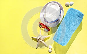 Set travel accessories on yellow background. Beach hat, sunglasses, towel, starfish, shells for woman`s summer holidays. Banner