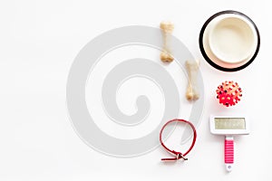 Set of treats and toys for pets with bones, collar and bowl on white backgrond top view flat lay frame space for text