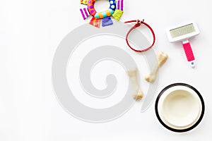 Set of treats and toys for pets with bones, collar and bowl on white background top view frame copy space