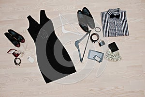 Set of trendy clothes. Outfit of man and woman clothes and accessories on light wooden background