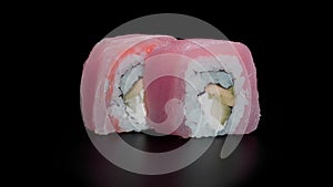 Set of tuna rolls with cucumber, avocado, masago and cream cheese on a black background