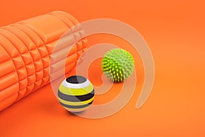 Set of two myofascial release and massage balls, bumpy foam massage roller for trigger points over orange background