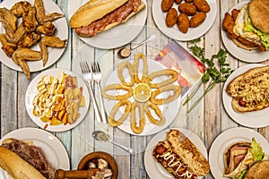 set of typical food dishes served in Spanish taverns. Squid a la romana, patatas bravas, fried wings, bacon sandwich, homemade