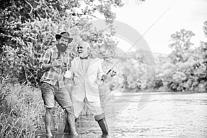 Set up rod with hook line and sinker. Fishing and drinking beer. Bearded man and elegant businessman fishing together