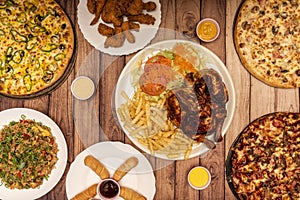 Set of varied fast food dishes, various pizzas, carbon-roasted chicken with fries and salad, fried rice, teques and fried chicken photo