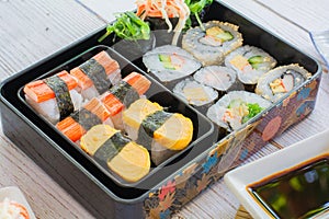 variety sushi, Tamagoyaki, crabsticks sushi and maki in bento box served with soy sauce and wasabi. Delicious japanese food