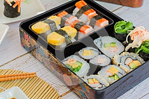 Set of variety sushi, Tamagoyaki, crabsticks sushi and maki in bento box served with soy sauce and wasabi. Delicious japanese food