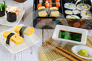 variety sushi on white plate and bento box served with soy sauce and wasabi. Delicious japanese food