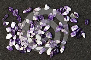 Set of various amethyst natural mineral stones and gemstones on black background