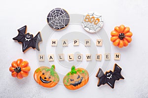 Set of various gingerbread cookies and Happy Halloween wooden blocks on white background. Bright homemade cookies for