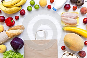 Set of various groceries with paper bag on white wooden table. Cooking food background. Flat lay of fresh foods. Top view, overhea