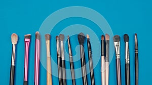 Set of various make up brushes on a blue background
