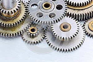 Set of various old metal machinery gears on scratched background