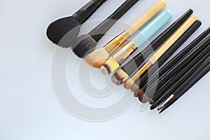 Set of various professional cosmetic makeup brushes on a light background close-up