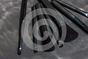 Set of various professional cosmetics brushes for makeup on a black background.