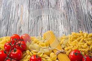 Set various raw ingredients for cooking Italian pasta on gray table, top view