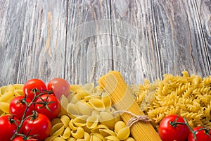 Set various raw ingredients for cooking Italian pasta on gray table, top view