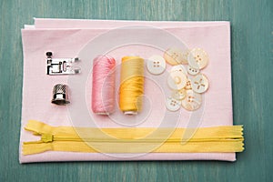 Set of various sewing supplies on wooden colorful surface