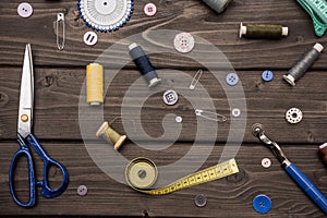 Set of various sewing supplies on wooden surface