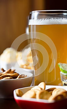 Set of various snacks, pint of lager beer in a glass, a standard set of drinking and eating in a pub