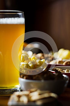 Set of various snacks, pint of lager beer in a glass, a standard set of drinking and eating in a pub