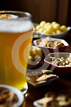 Set of various snacks, pint of lager beer in a glass, a standard set of drinking and eating in a pub